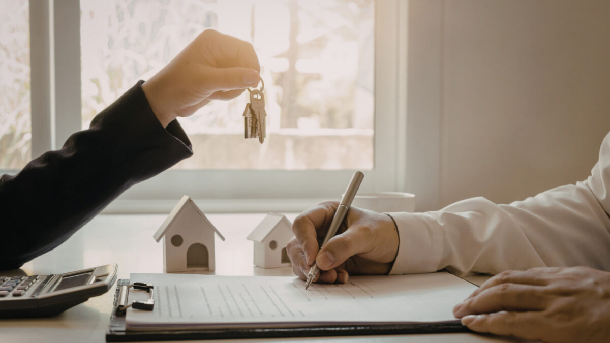 Buyer receiving house keys while signing paperwork for a home purchase in High Springs FL.