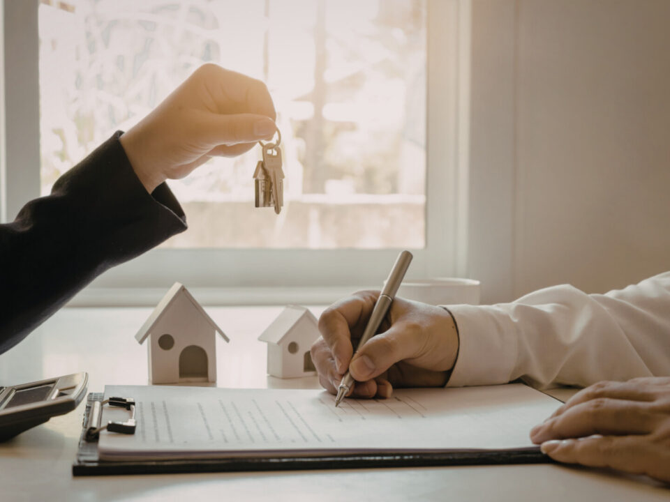 Buyer receiving house keys while signing paperwork for a home purchase in High Springs FL.