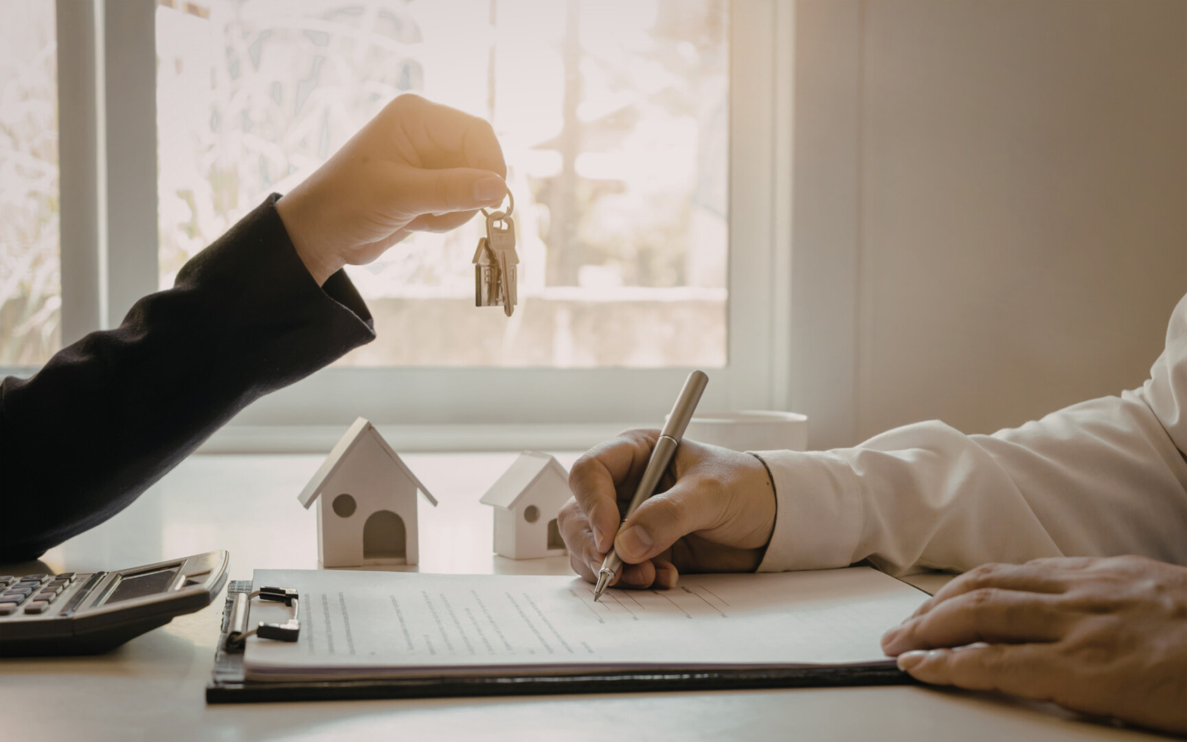 Buyer receiving house keys while signing paperwork for a home purchase in High Springs FL.