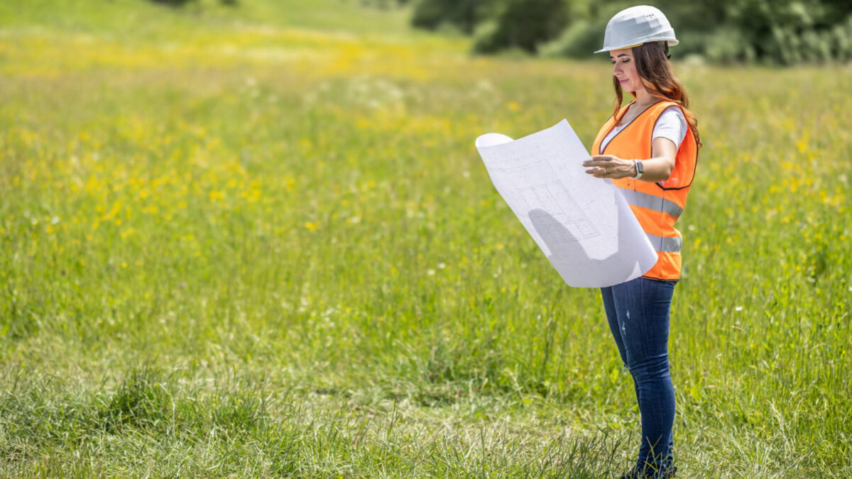 Developer reviewing construction plans on undeveloped land in High Springs, Florida, representing residential growth and homebuilder opportunities.
