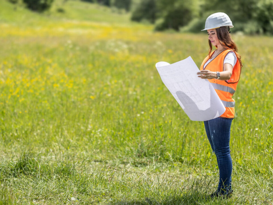 Developer reviewing construction plans on undeveloped land in High Springs, Florida, representing residential growth and homebuilder opportunities.
